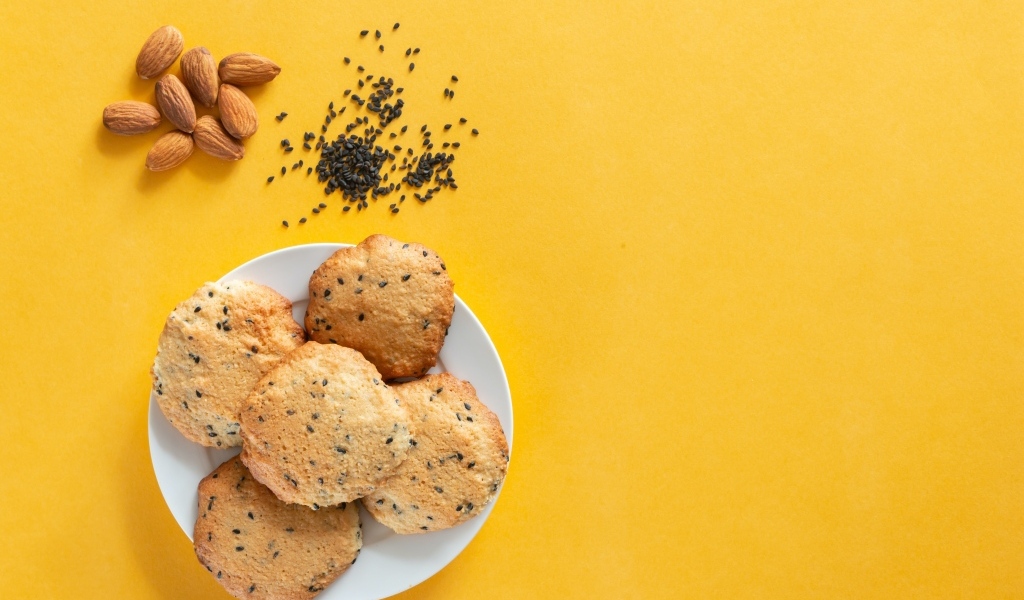 Печенье на желтом фоне с кунжутом и миндальным орехом