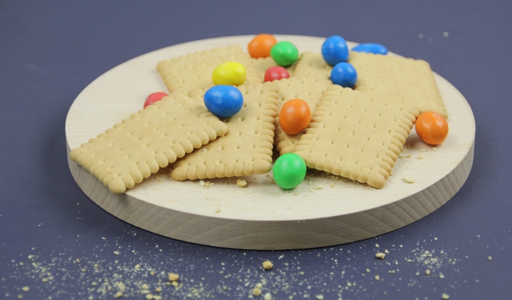 Печенье с разноцветными конфетами на сером фоне