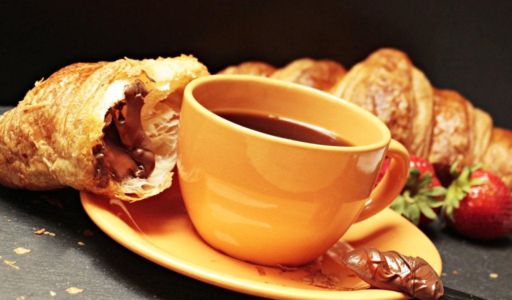 Чашка кофе на тарелке с круассанами