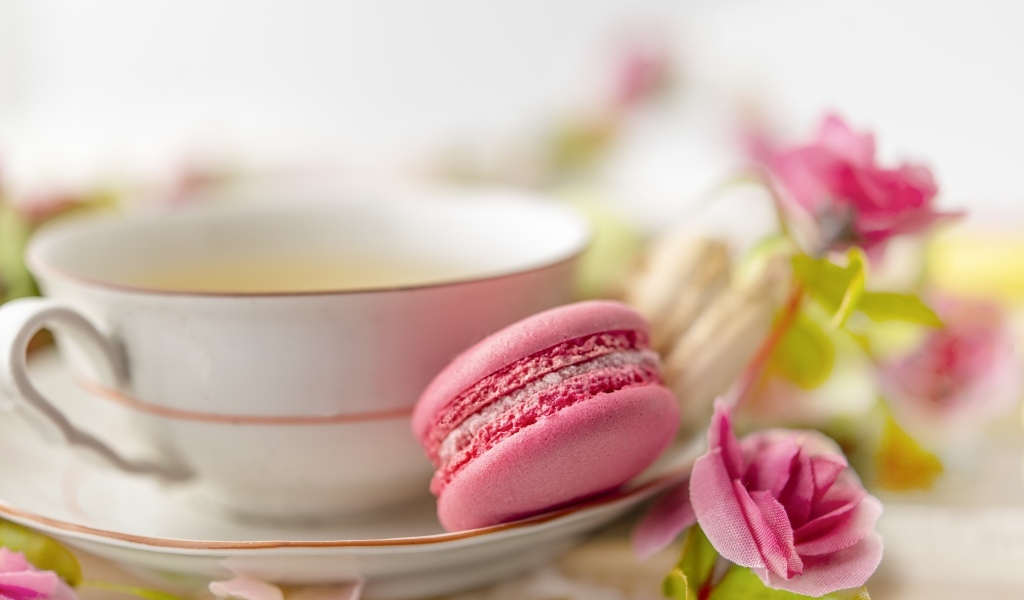 Чашка чая с десертом макарун и цветами розы