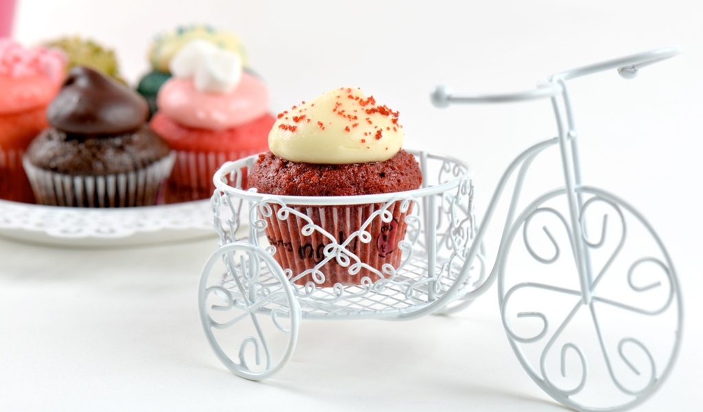 Кекс с кремом с игрушечным велосипедом