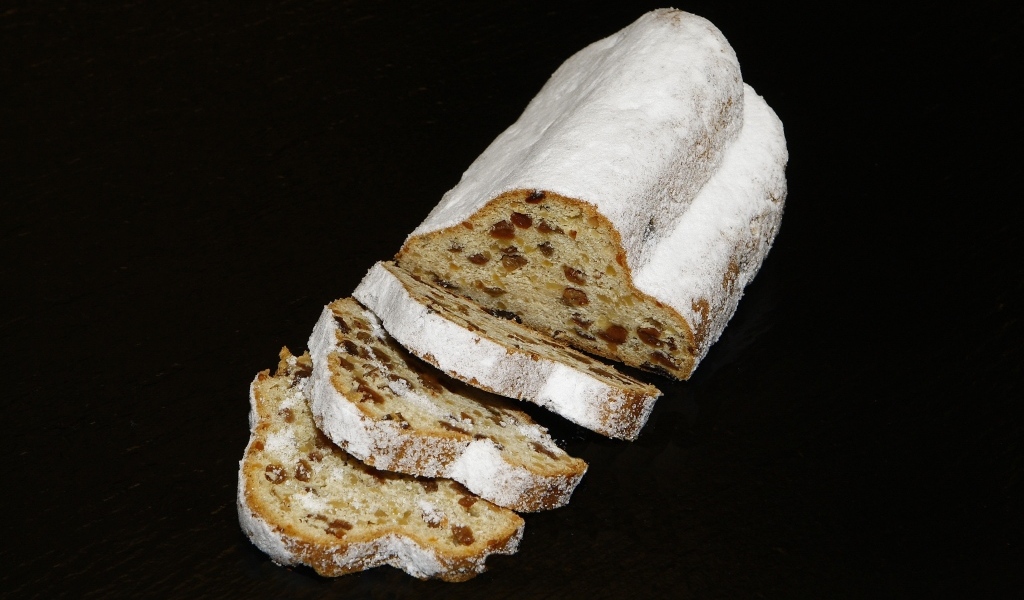 Кекс с изюмом и сахарной пудрой на черном фоне