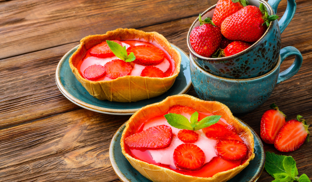 Вкусные пирожные с ягодами клубники на тарелке