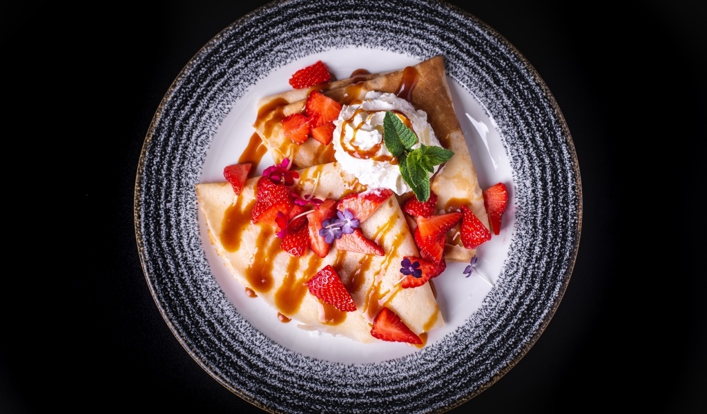 Вкусные сладкие блинчики на тарелке с ягодами