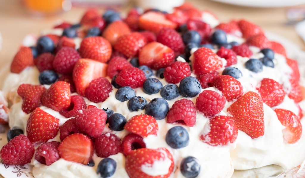 Десерт с кремом и свежими ягодами малины, клубники и черники