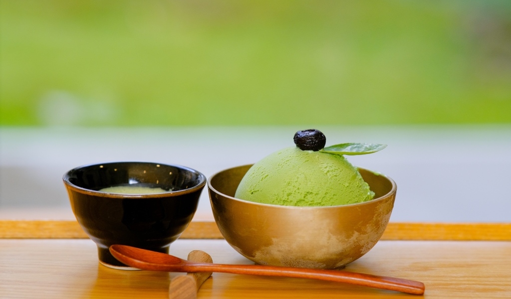 Зеленый шарик мороженого в чашке на столе