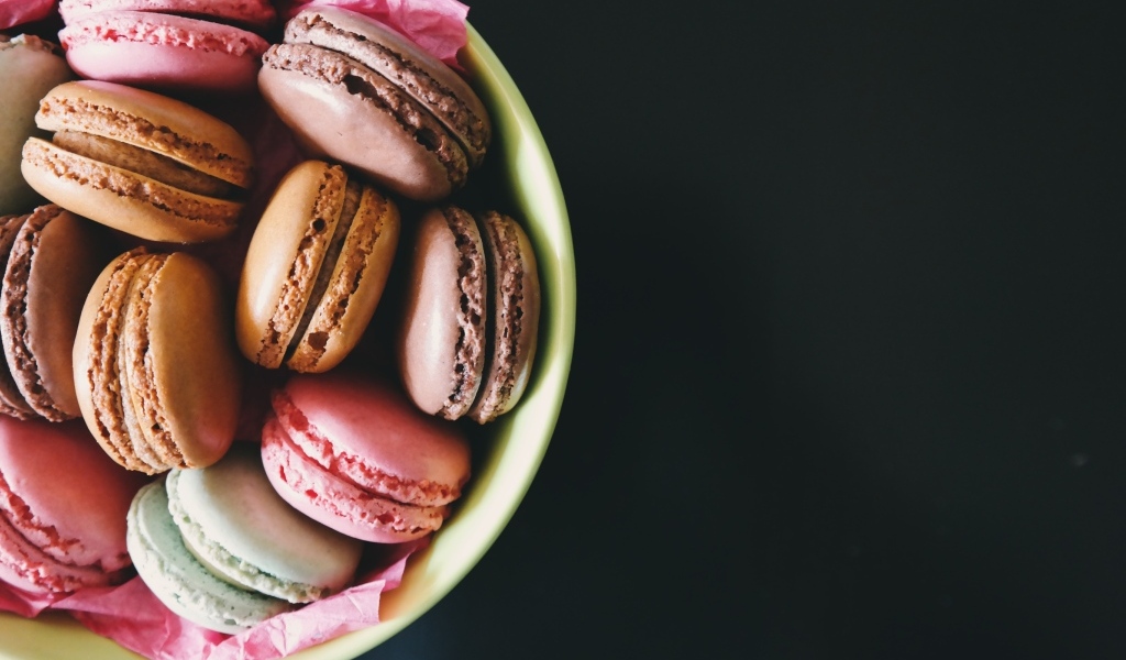 Десерт макарун в миске на черном фоне
