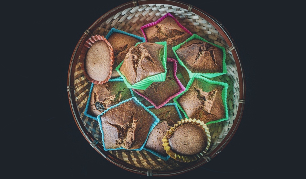 Много кексов в корзине на черном фоне