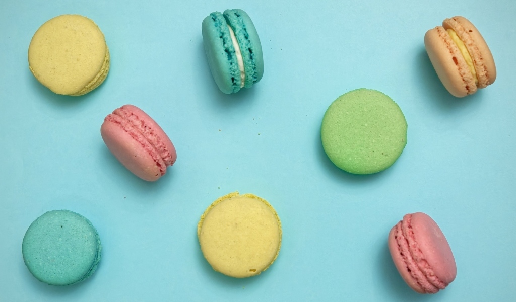 Разноцветный десерт макарон на голубом фоне