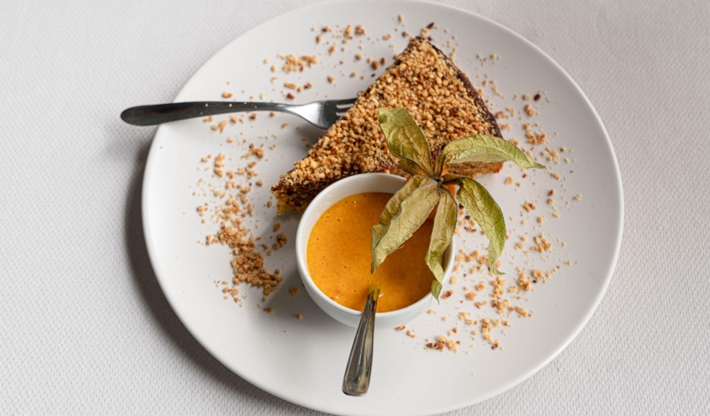 Кусок торта на белой тарелке с соком 