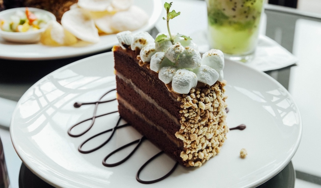 Кусок шоколадного торта с маршмеллоу на белой  тарелке