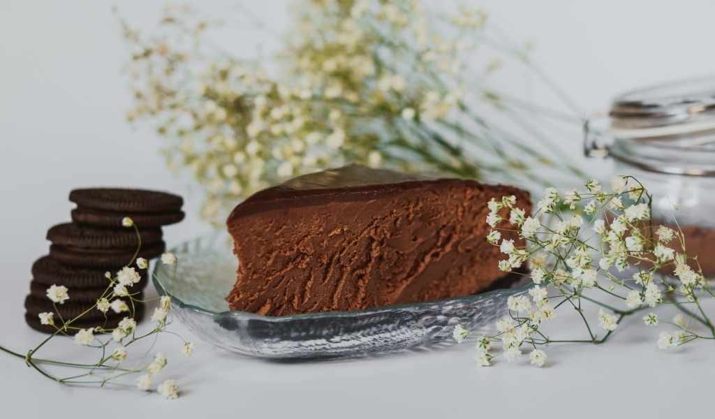 Кусок шоколадного пирога с белыми цветами гипсофилы