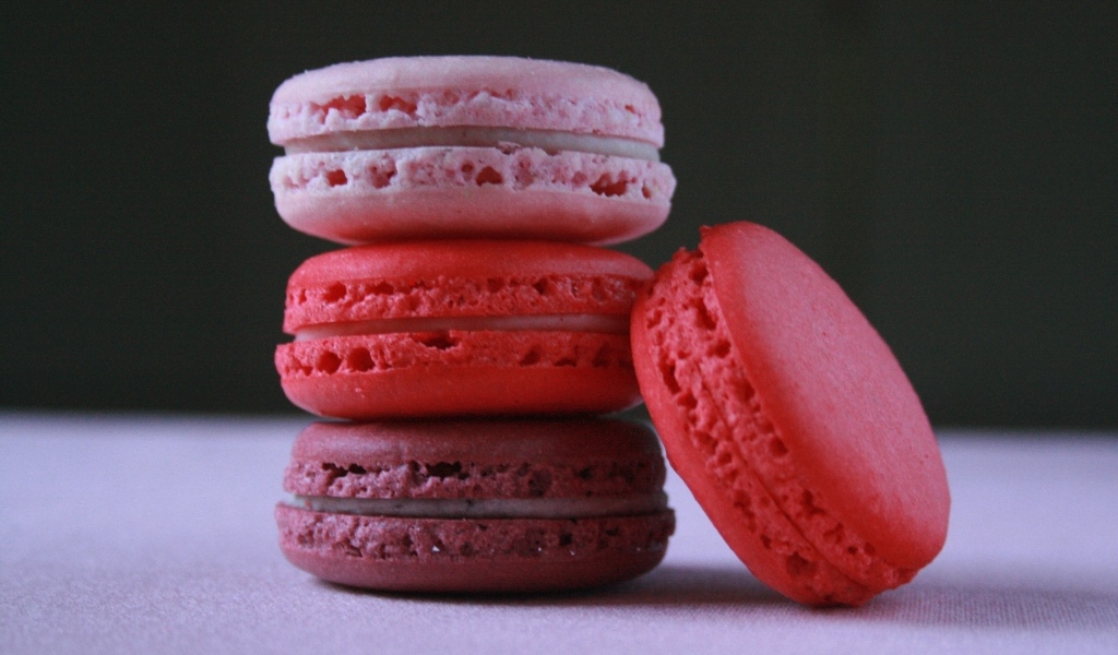 Розовый десерт макарон на столе 