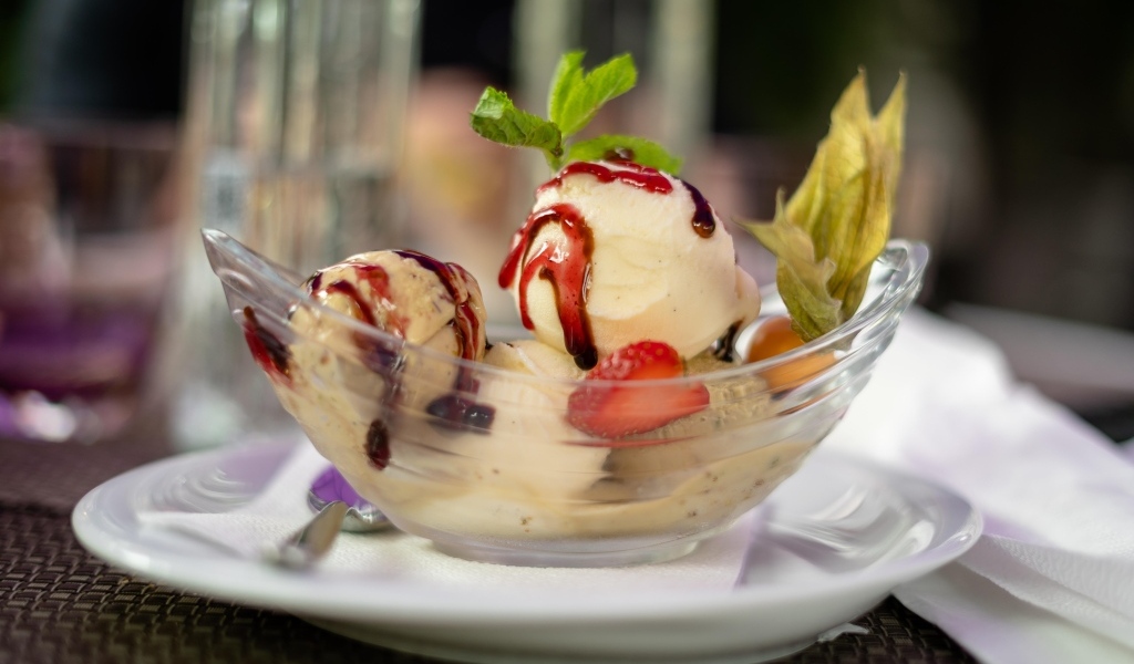 Шарики фруктового мороженого в стеклянной пиале на столе