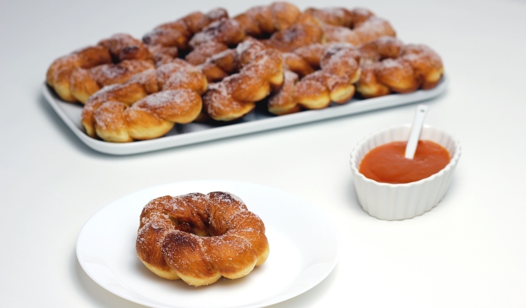 Сладкие пончики в сахарной пудре на столе