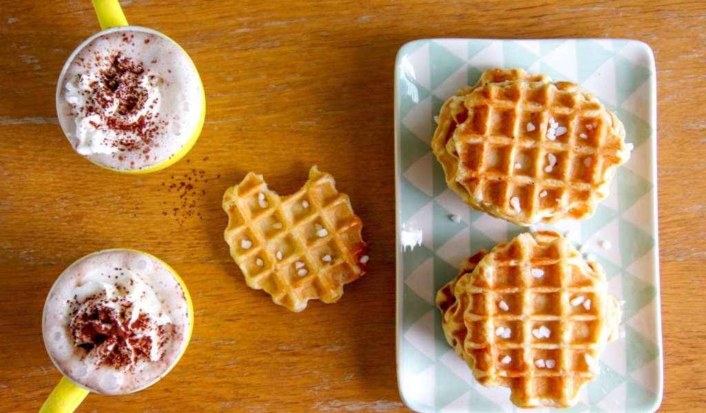 Сладкие вафли на столе с капучино