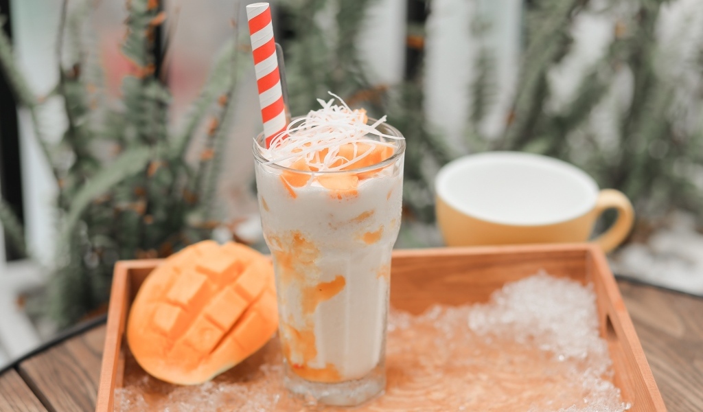 Коктейль с манго в стакане на столе