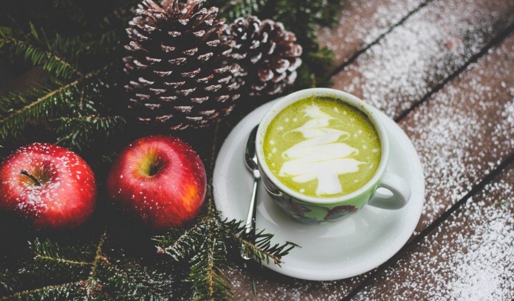 Чашка кофе на столе с яблоками и шишками