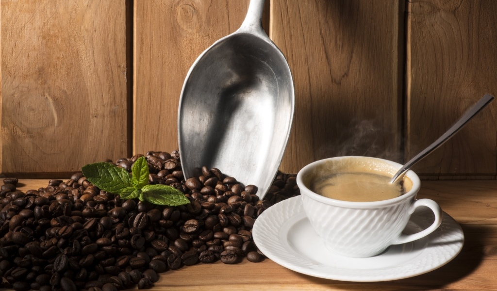 Чашка кофе на столе с ароматными зернами