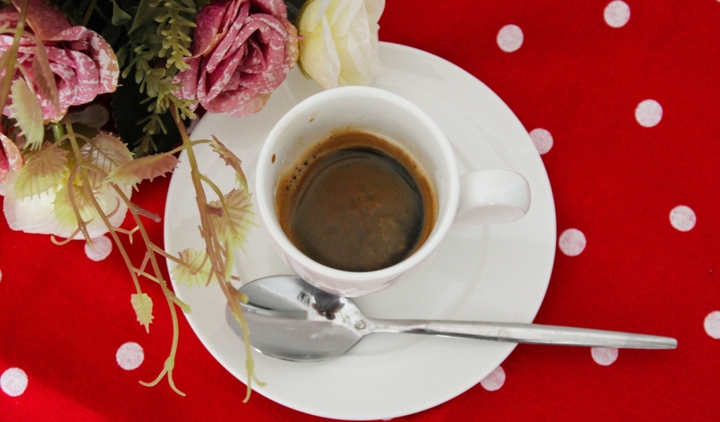 Чашка кофе на столе с цветами розы