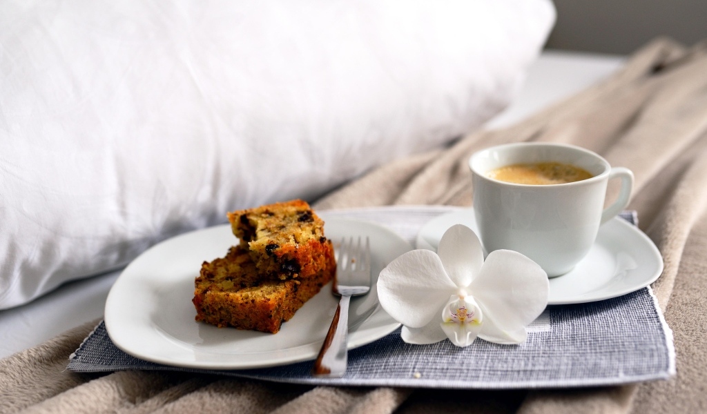 Чашка кофе с цветком орхидеи и кусочками кекса