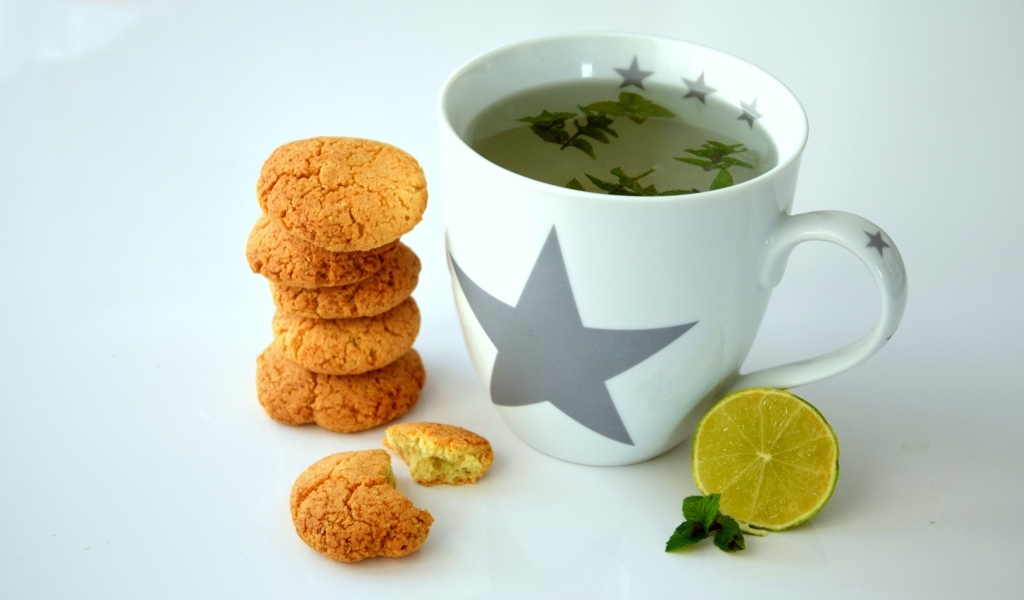 Чашка чая на столе с лимоном и печеньем