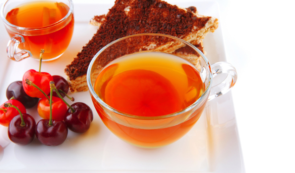 Чашка чая с тортом и ягодами черешни