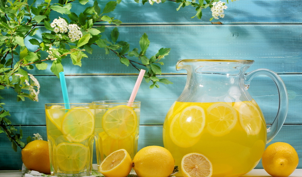Графин с лимонадом на столе с фруктами