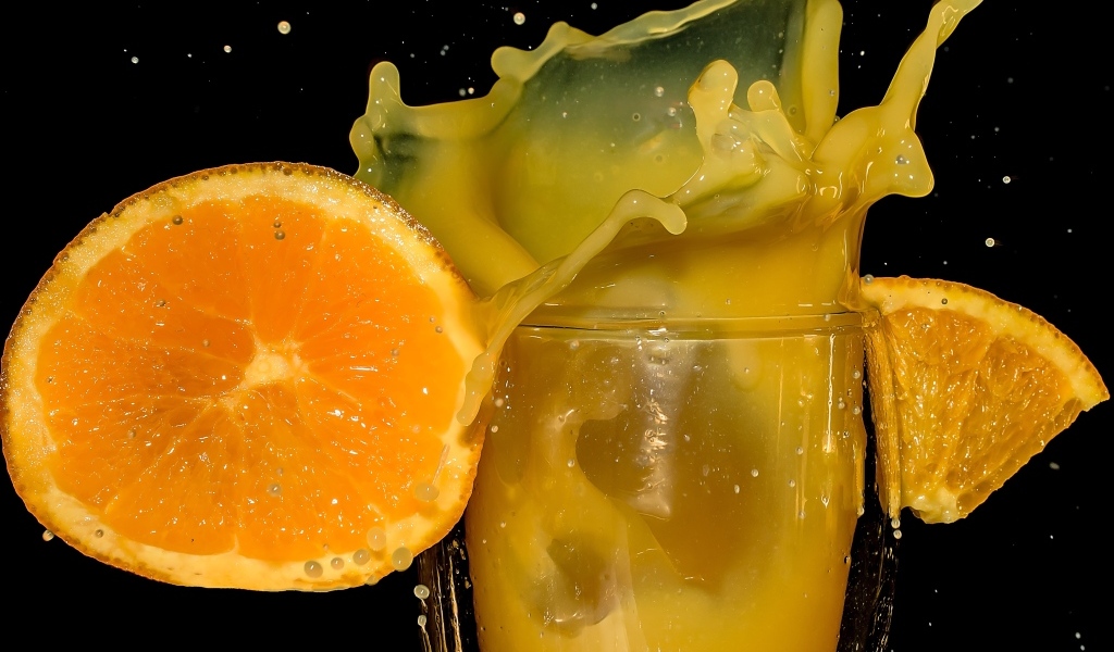 Свежий апельсиновый сок на черном фоне
