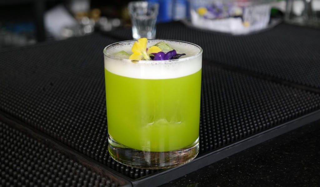 Зеленый коктейль в стакане с цветами