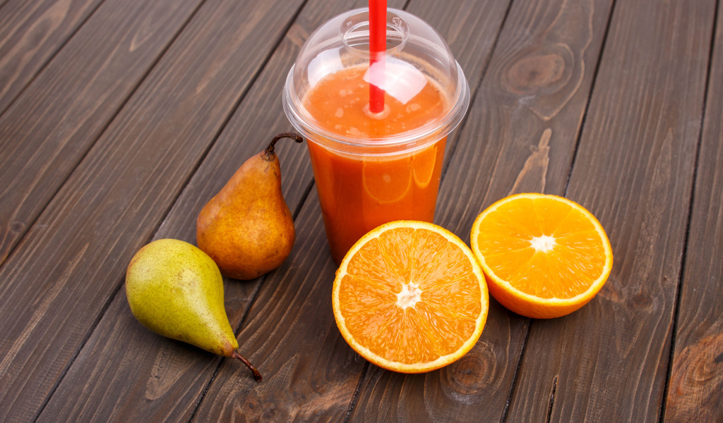 Сок на столе с грушами и апельсином