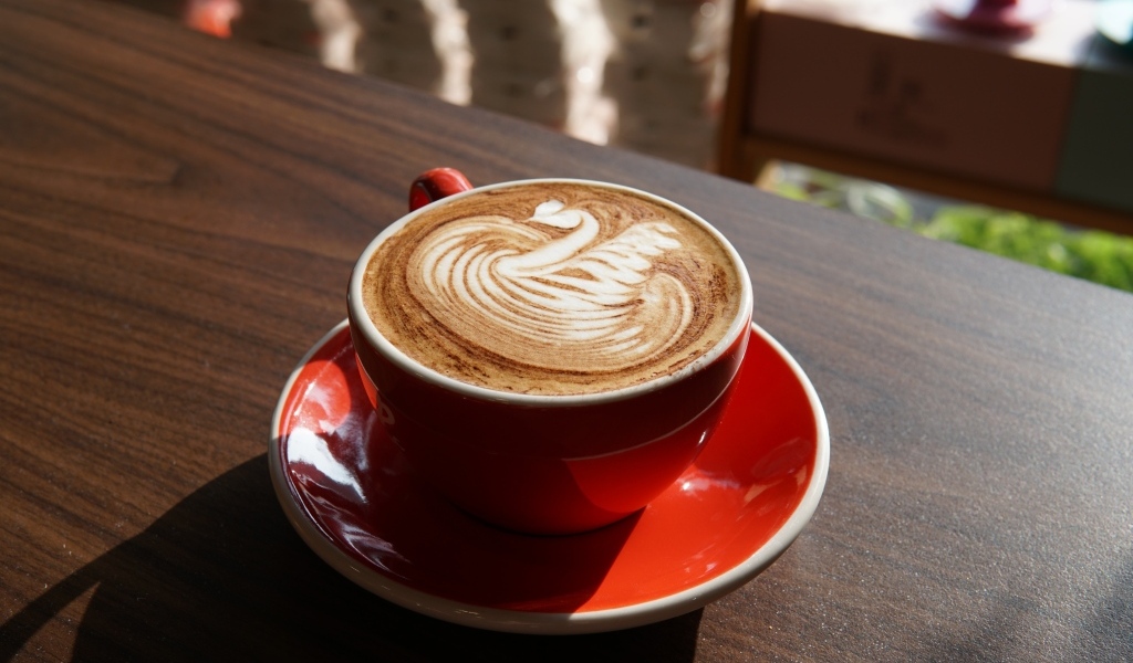 Латте с красивой пенкой в красной чашке