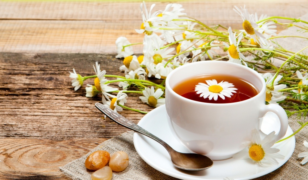 Чай на столе с цветами ромашки и конфетами