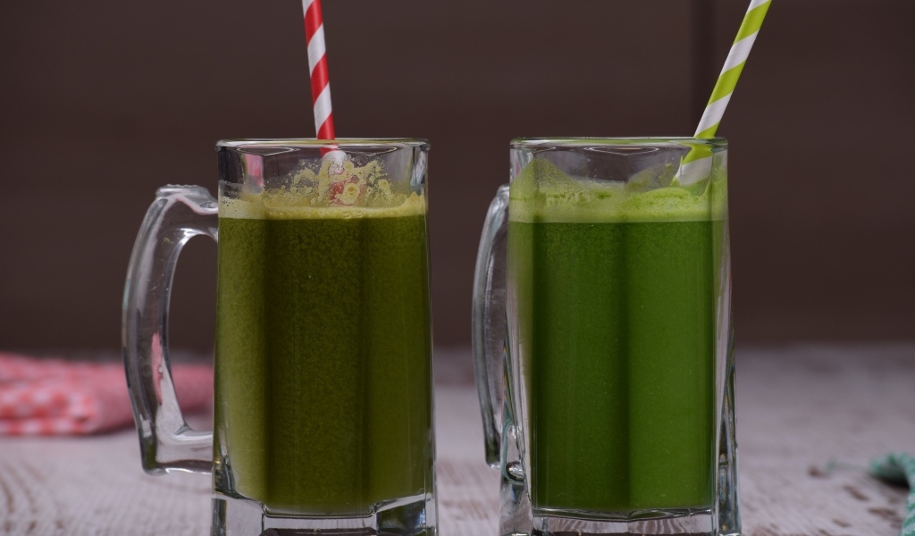 Два стакана зеленого смузи с трубочками