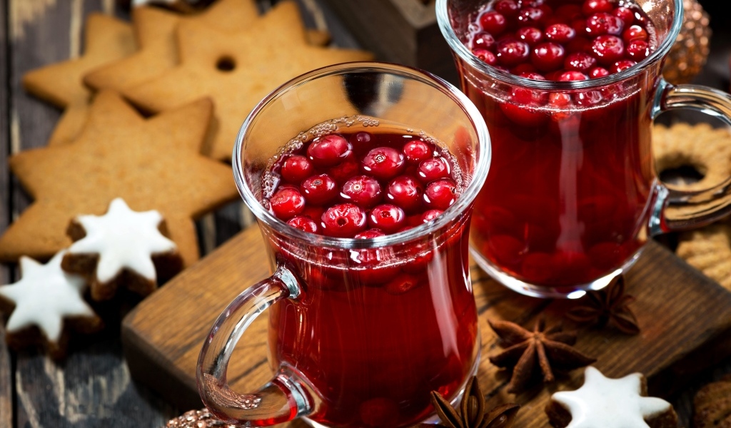 Две кружки клюквенного морса на столе с печеньем
