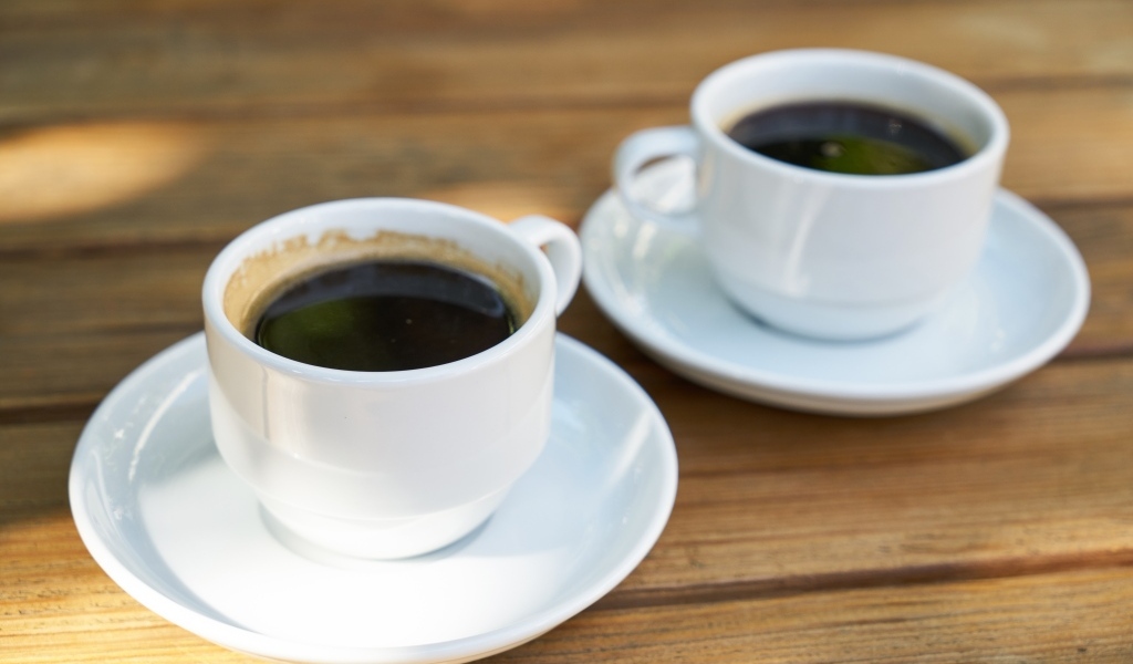 Две белые чашки кофе на столе 