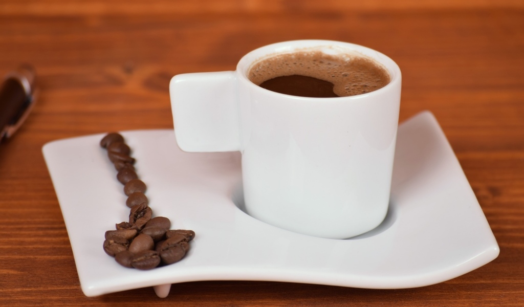 Белая чашка горячего кофе на столе 