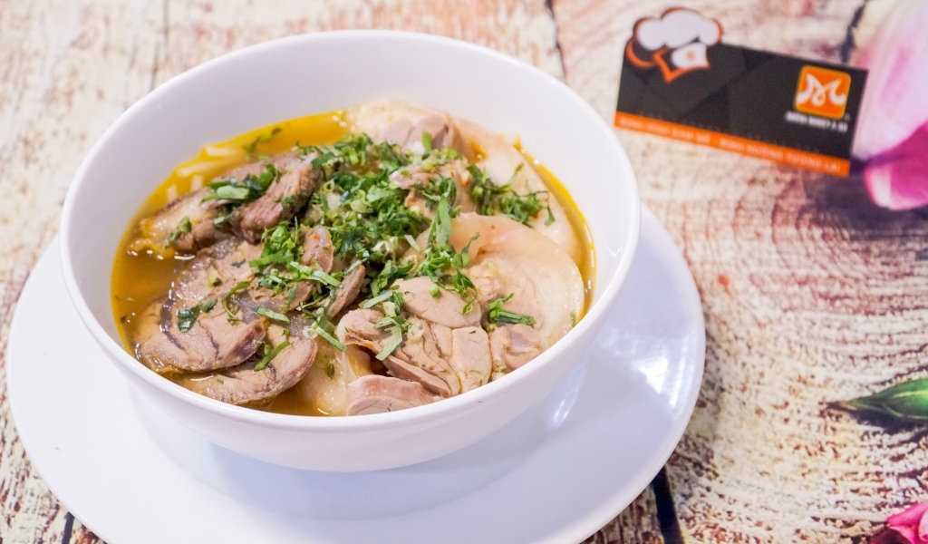 Бульон с мясом в белой тарелке на столе