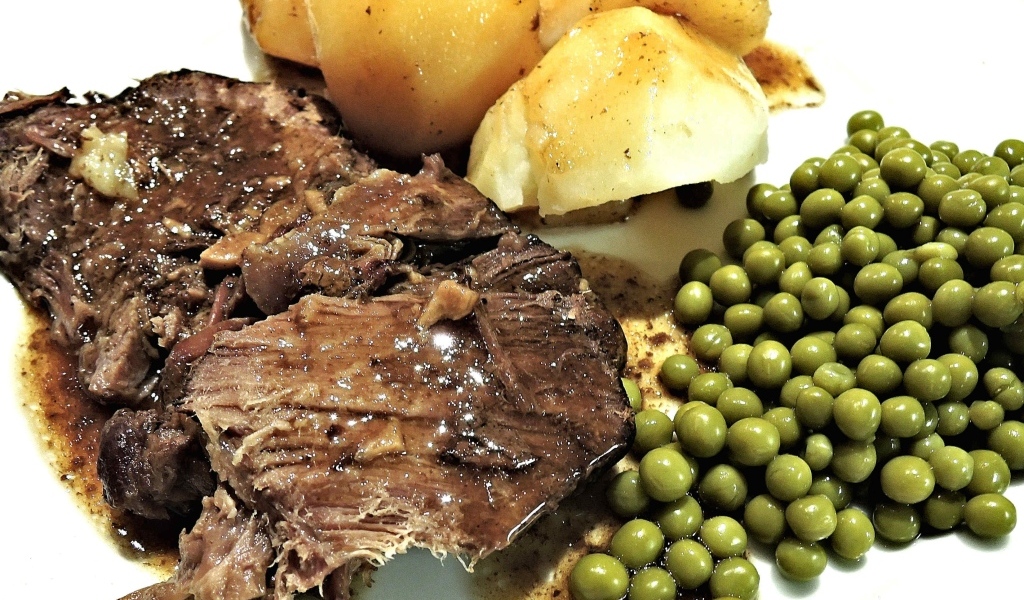 Кусок мяса с картофелем и зеленым горошком