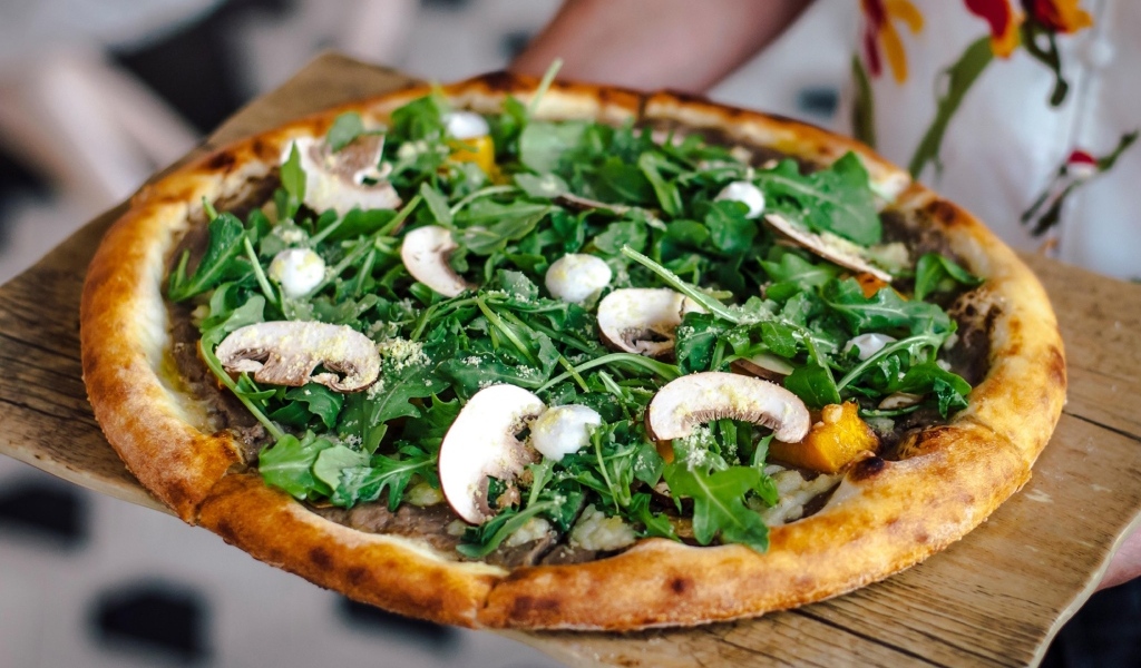 Пицца с грибами и листьями рукколы