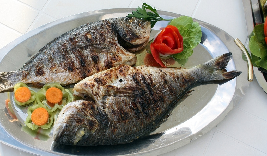 Запеченная рыба на тарелке с овощами