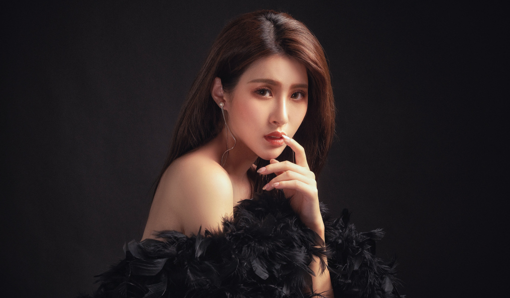 Девушка азиатка в боа на черном фоне