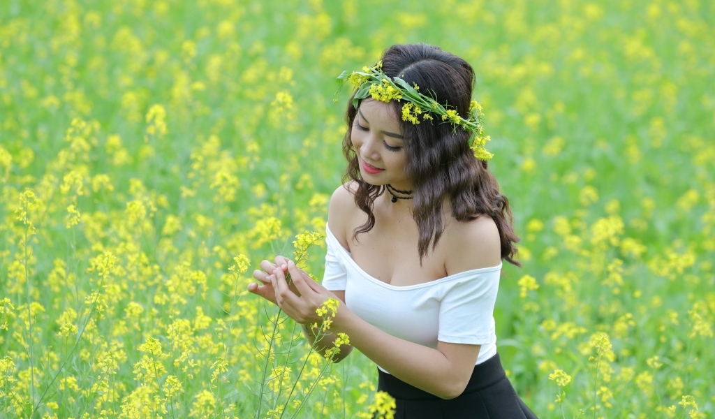 Девушка азиатка на рапсовом поле