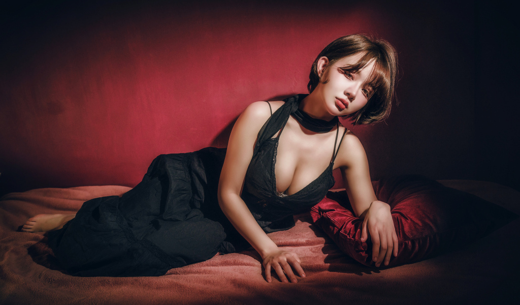 Девушка азиатка лежит на постели