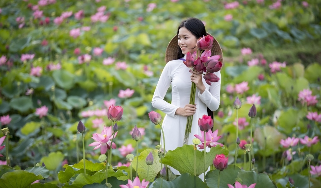 Девушка азиатка с розовыми цветами лотоса в руках