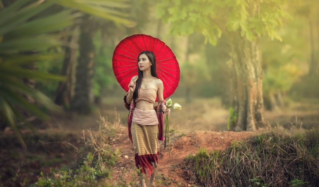 Девушка азиатка с красным зонтом и цветами лотоса