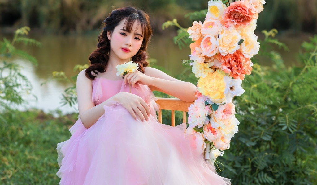 Красивая девушка азиатка в розовом платье с цветами