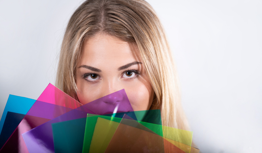 Красивая кареглазая девушка с разноцветной бумагой