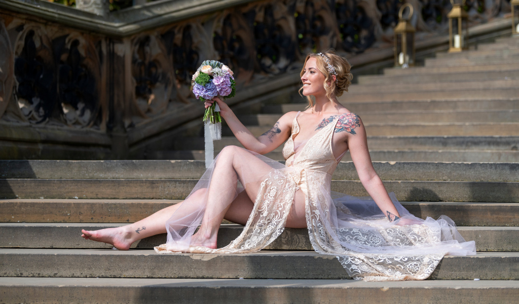Красивая девушка невеста в платье с букетом на ступеньках