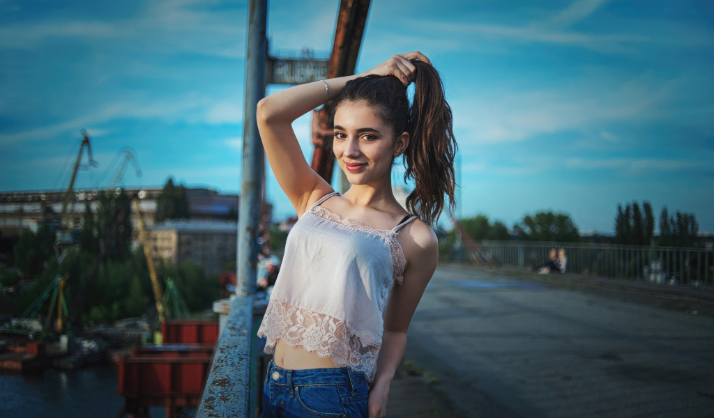 Красивая девушка держит волосы рукой